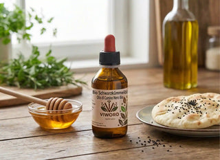 Olio di cumino nero su un tavolo di legno con miele e pane, pronto per l'assunzione quotidiana.
