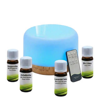 Diffusore di aromi a ultrasuoni con base effetto legno illuminato di blu, circondato da quattro flaconcini di oli essenziali generici.