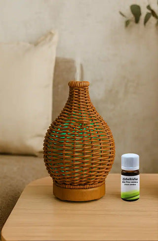 Diffusore in rattan con bottiglia di olio essenziale su tavolo