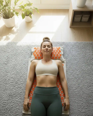 Una donna in abbigliamento sportivo sdraiata sul tappetino per agopressione Viworo, che esegue il suo rituale di benessere e rilassamento.