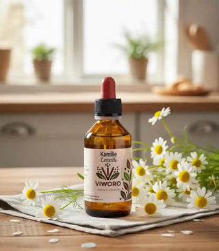 L'estratto di Camomilla Viworo su un tavolo da cucina rustico, accanto a un mazzo di fiori di camomilla fresca.