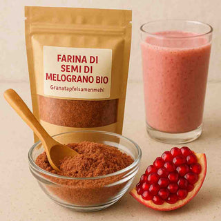 Farina di Semi di Melograno Bio con frullato rosa, cucchiaio e chicchi di melograno.