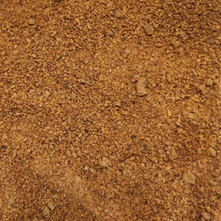Dettaglio ravvicinato della consistenza fine della farina di semi di melograno biologica.