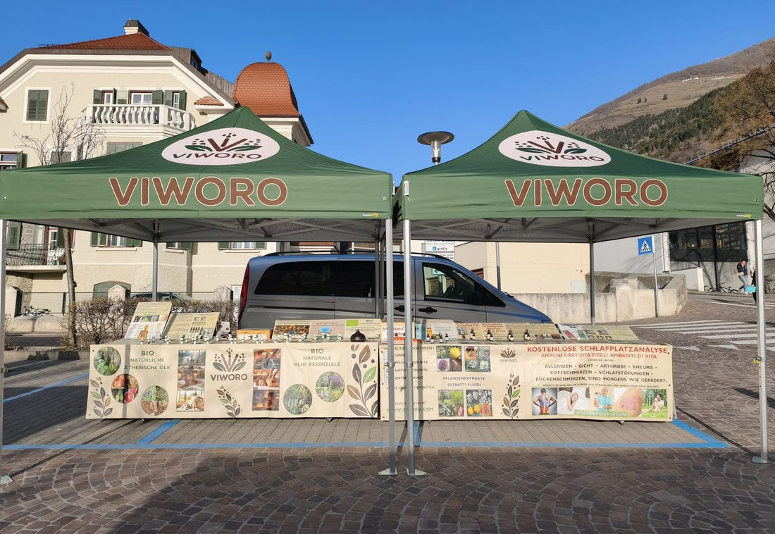 Il banco Viworo con i gazebo verdi a un mercato settimanale in Alto Adige