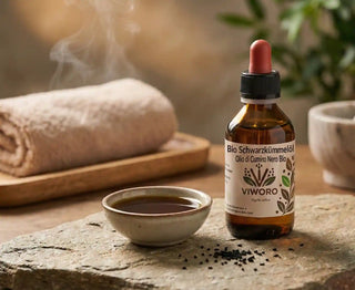 Olio di cumino nero in un ambiente spa rilassante con asciugamani, ideale per massaggi e cura della pelle.